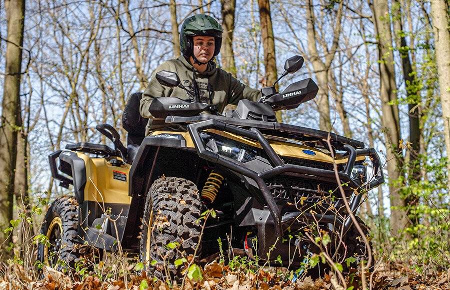 Linhai Landforce 1000L EPS w wersji piaskowej w lesie – kierowca pozuje na quadzie wśród drzew