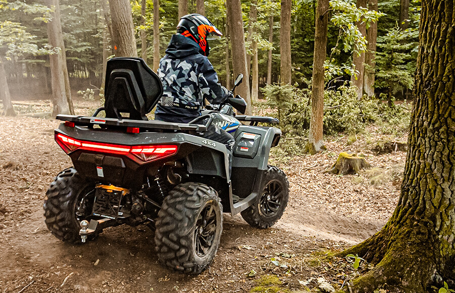 Linhai Landforce 550L EPS ABS w lesie – ujęcie od tyłu z włączonymi światłami stop